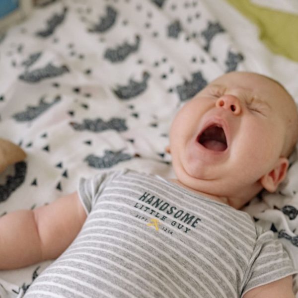 Gapende baby ligt op een dekentje
